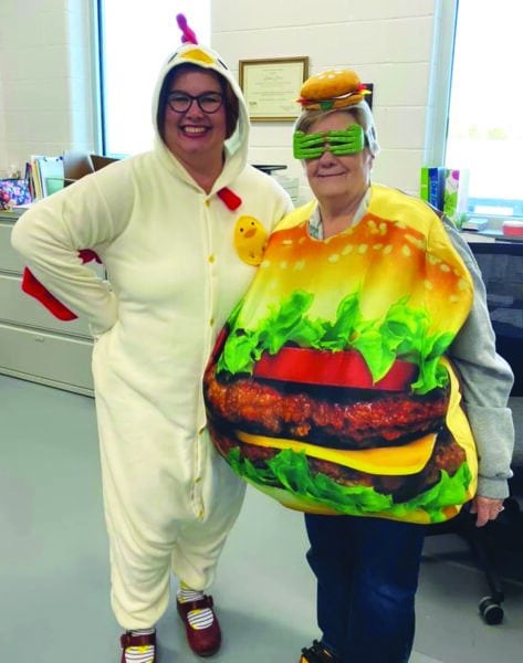 Anna Fails wearing a chicken costume with a coworker who is wearing a hamburger costume