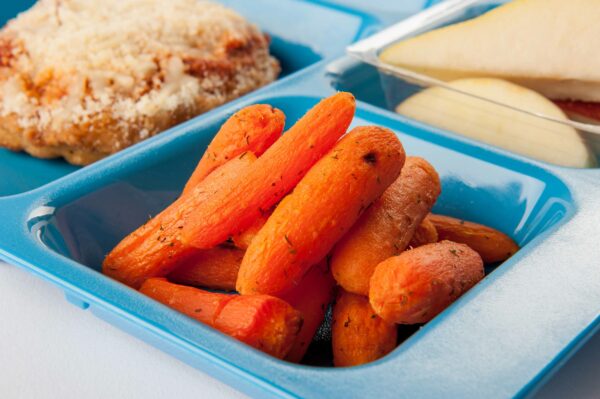 Lemon-roasted carrots on a blue cafeteria tray