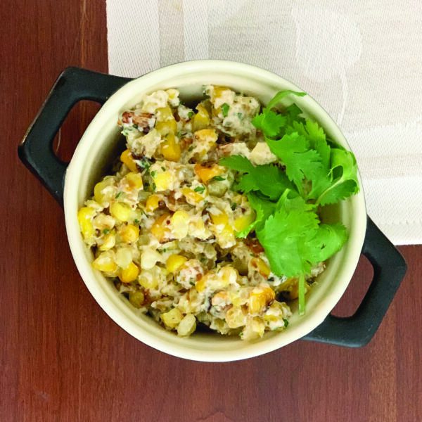 Mexican corn salad in a bowl on a wooden background