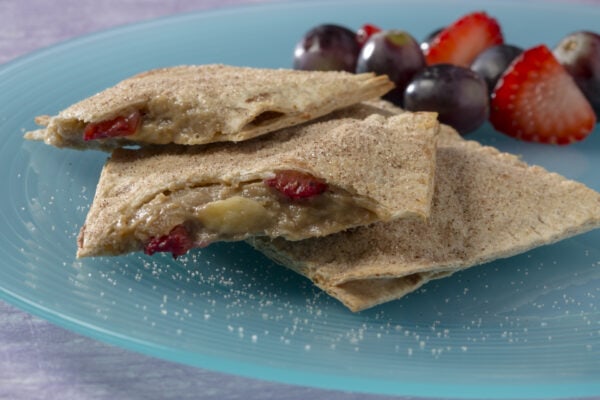 Peanut butter pockets on a blue plate with blueberries and strawberries in the background