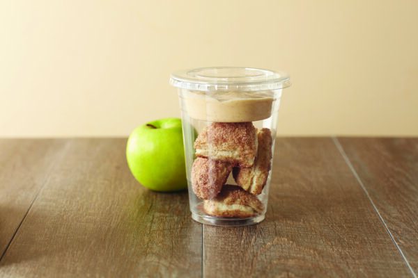 Cinnamon biscuits with pumpkin dip, served in a plastic cup alongside an apple