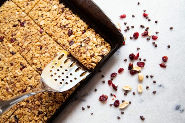 Granola bars in a black pan with a metal spatula