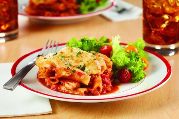 Baked Chicken Bolognese served on a plate with a lettuce and tomato salad
