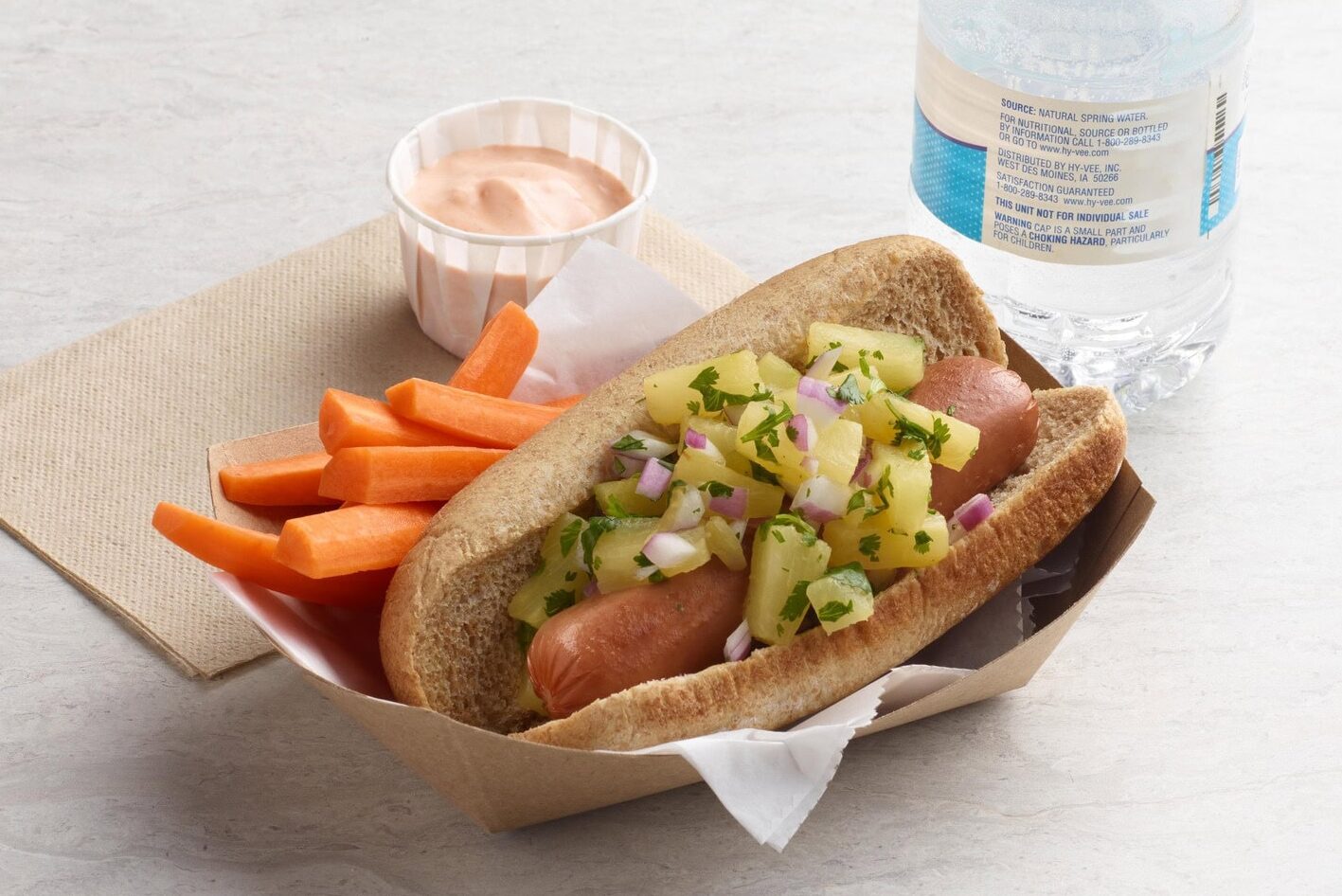 a hotdog topped with pineapple salsa