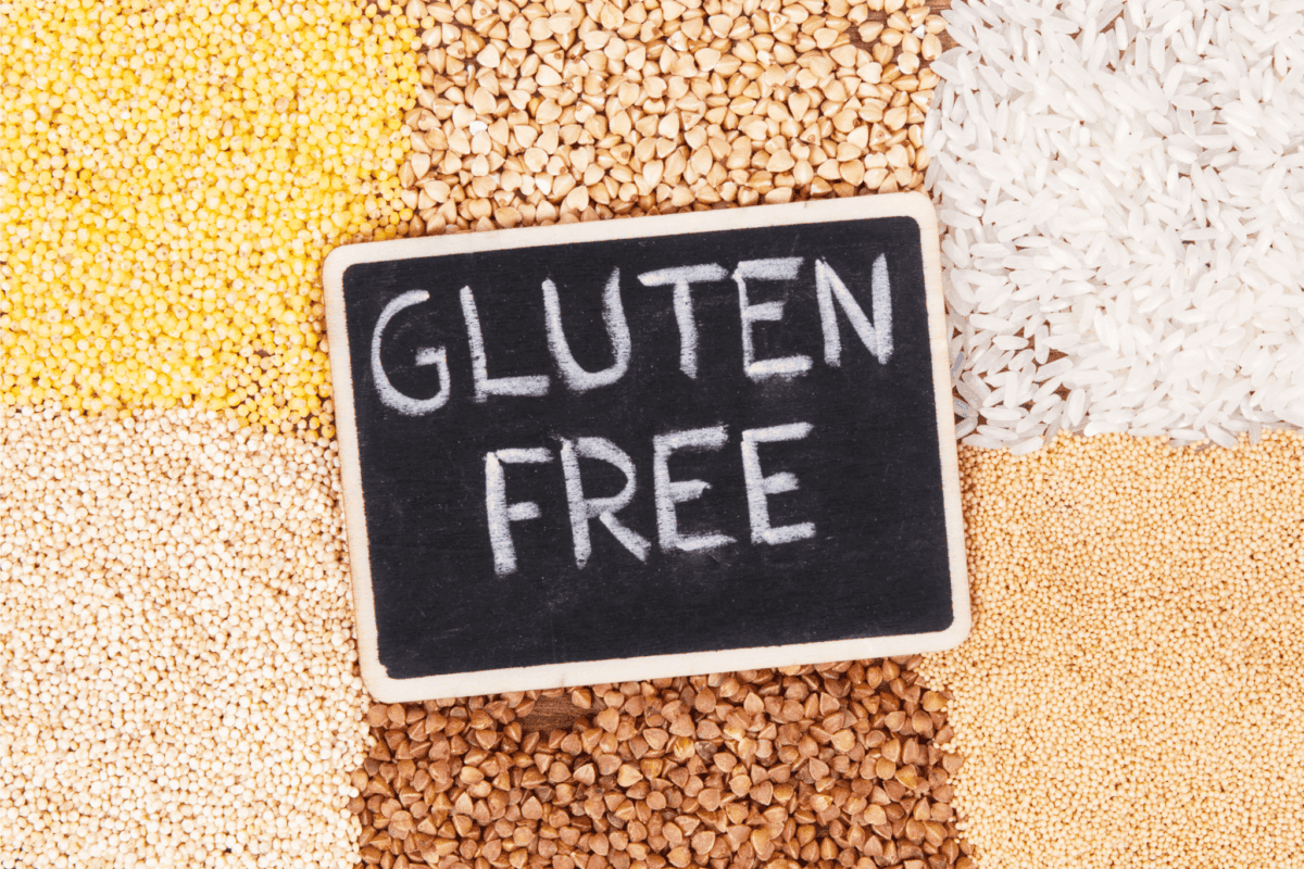 the words "gluten free" on a chalkboard on top piles of various gluten-free grains